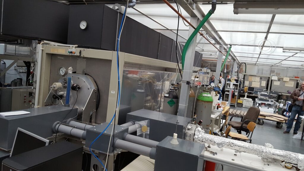 Industrielle Produktionsanlage mit Förderbändern und Maschinen in einer Fabrikhalle.