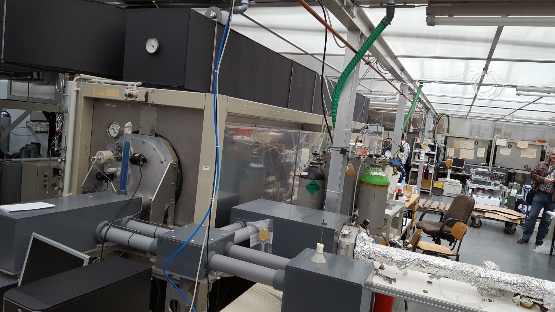 Industrielle Produktionsanlage mit Förderbändern und Maschinen in einer Fabrikhalle.