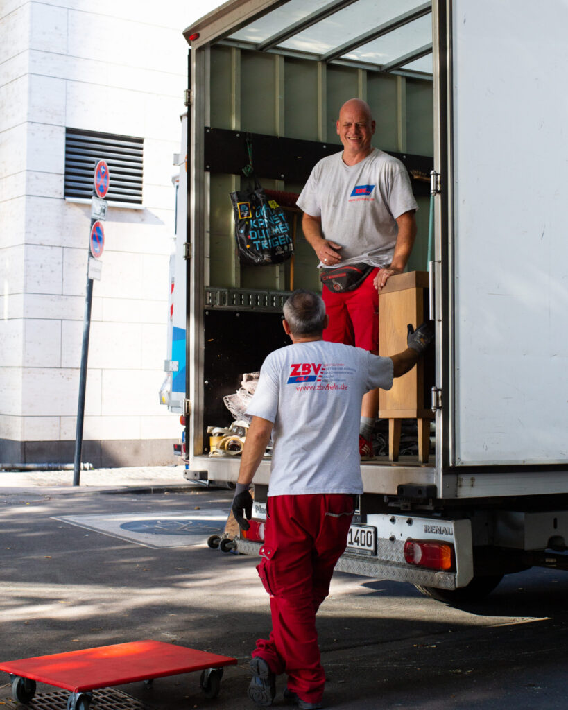 Two people, one in the truck and the other at the loading dock