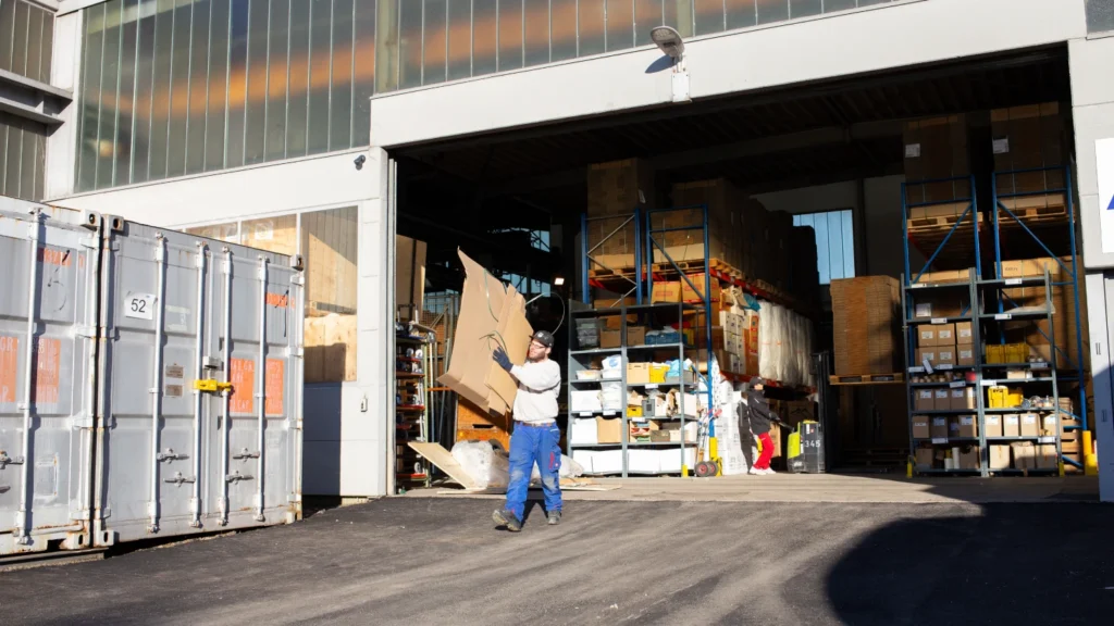 ZBV Fels employees transporting packaging materials in front of an industrial building – professional warehouse logistics and business relocation