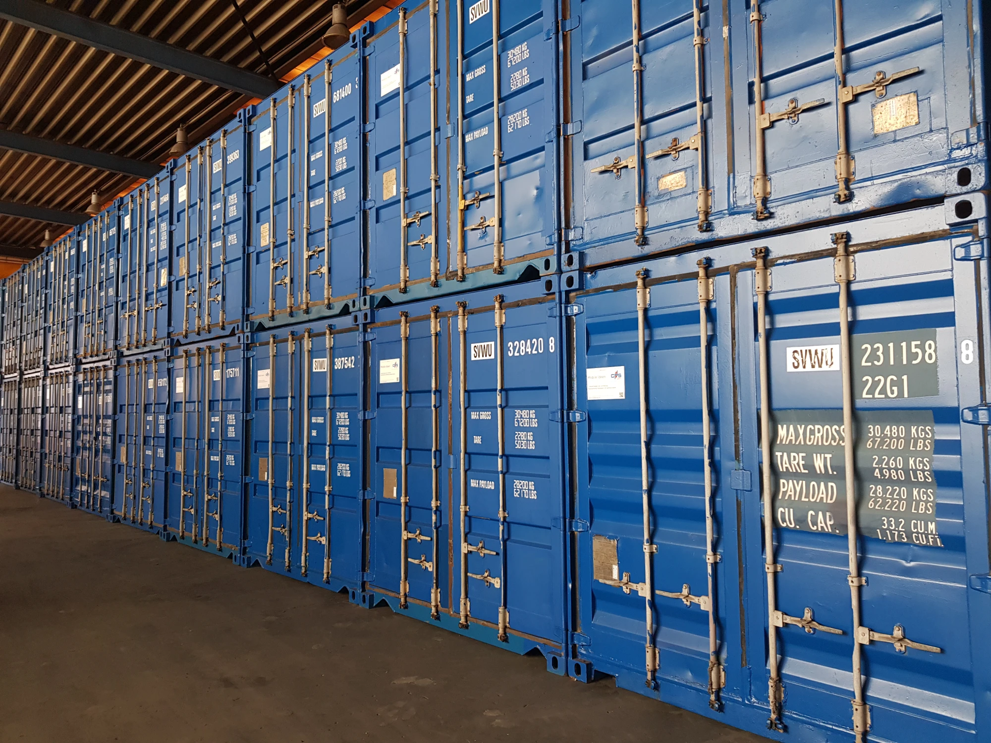 Reihe von blauen Frachtcontainern in einem Lagerhaus.