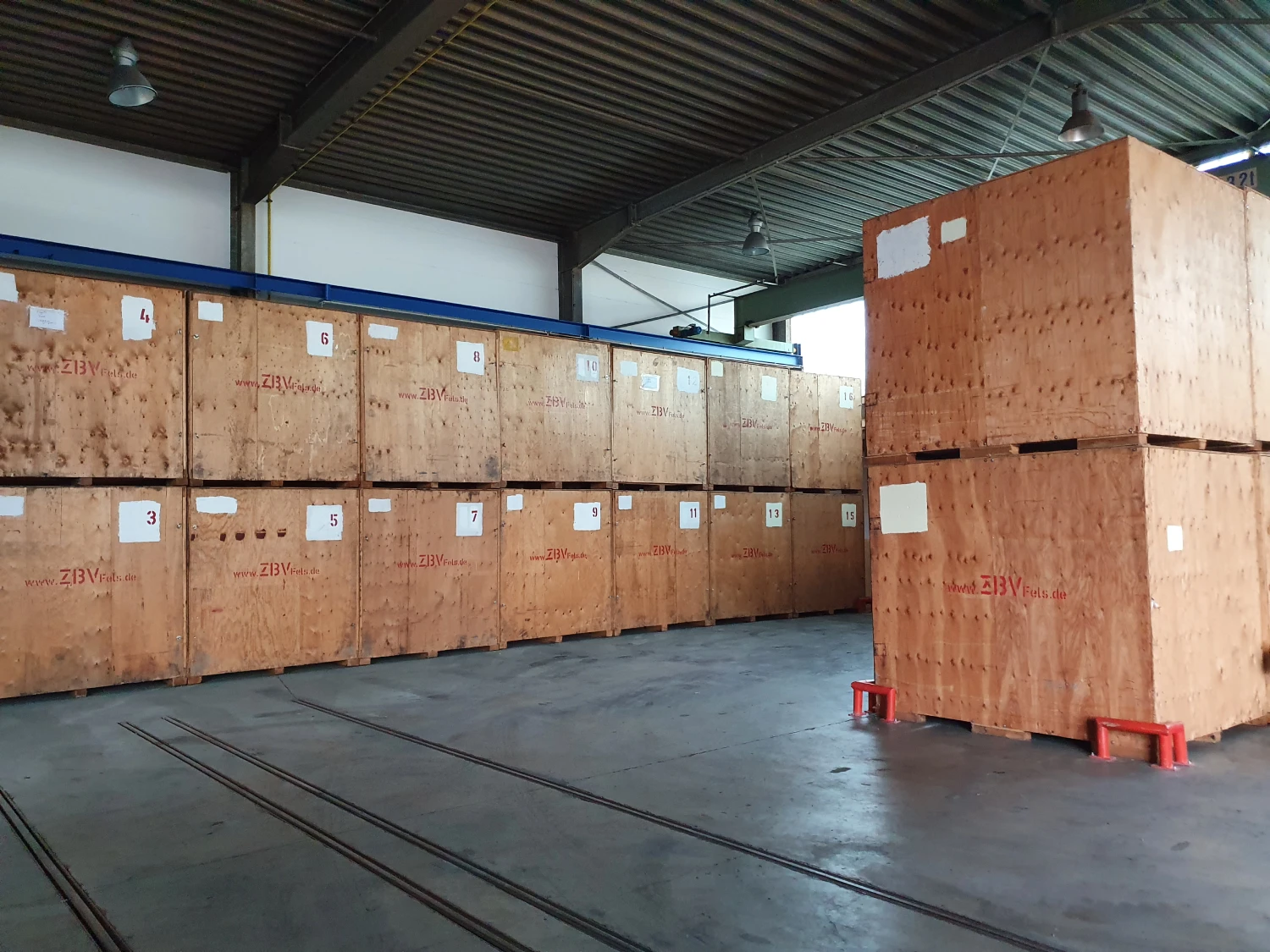 Große Holzkisten gestapelt in einem Lagerhaus.