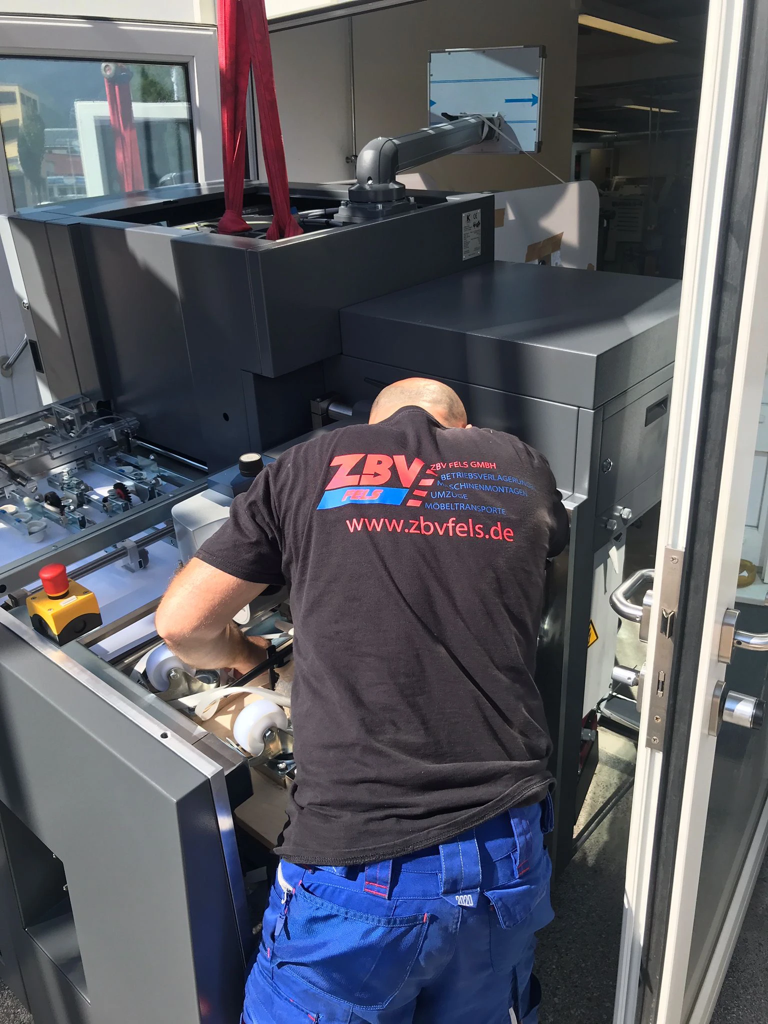 Techniker repariert oder wartet eine große industrielle Maschine in einer Werkstatt.