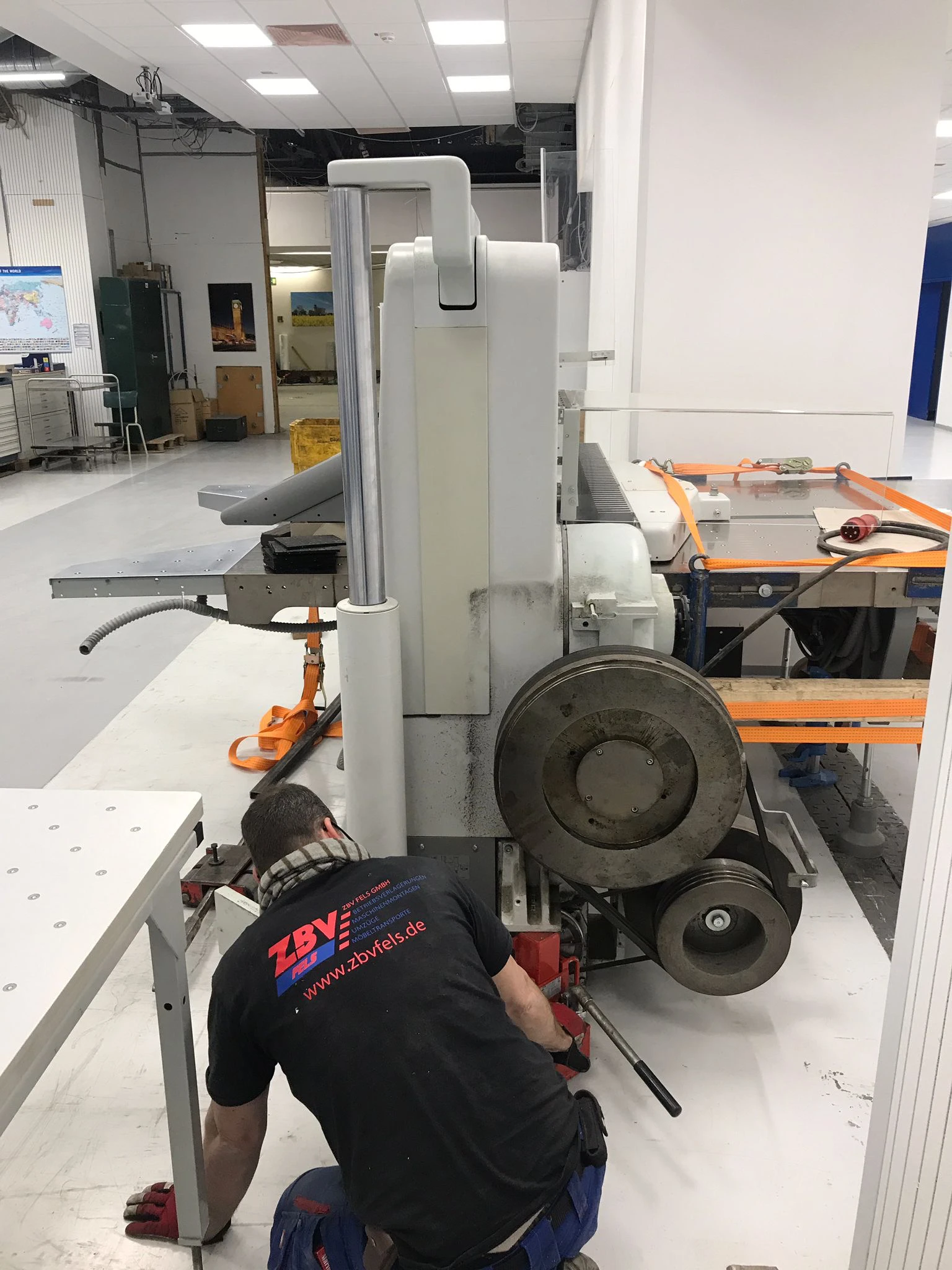 Person repariert oder wartet eine große industrielle Maschine in einer Werkstatt.