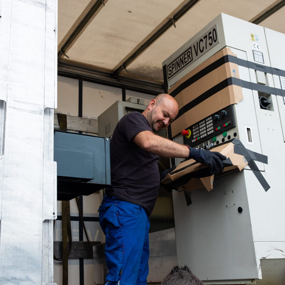 Mann inspiziert und sichert Industriemaschine Spinner VC750 im LKW