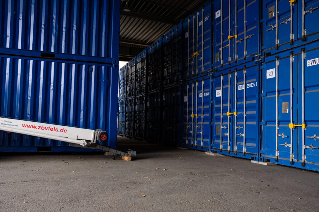 Warehouse with stacked blue containers and transportation equipment
