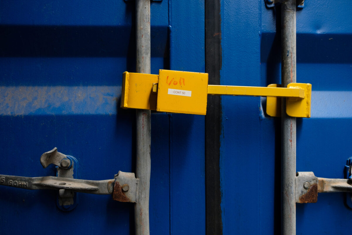 Nahaufnahme eines blauen Containers mit gelbem Sicherheitsschloss