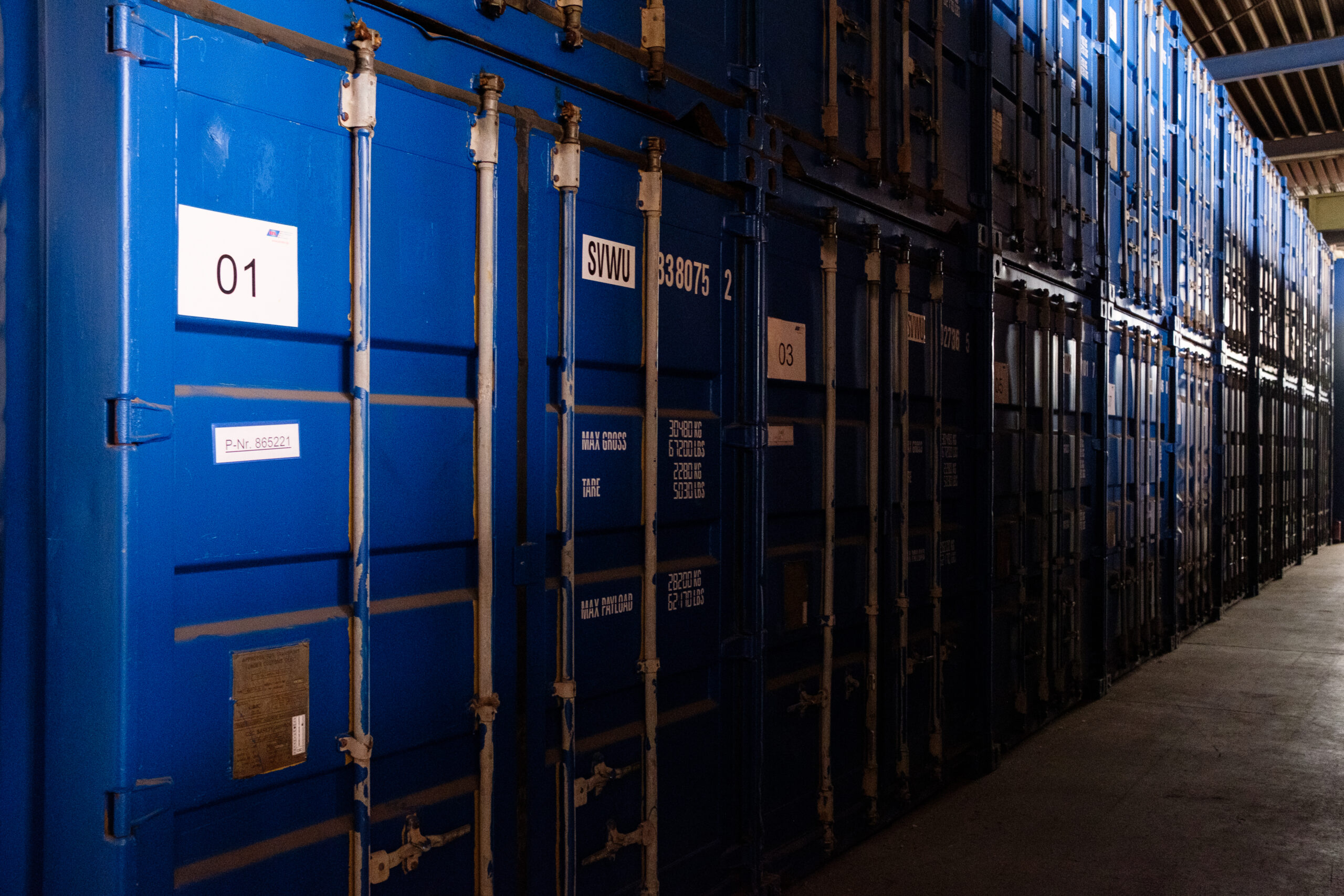 Reihe blauer Lagercontainer in einer Halle