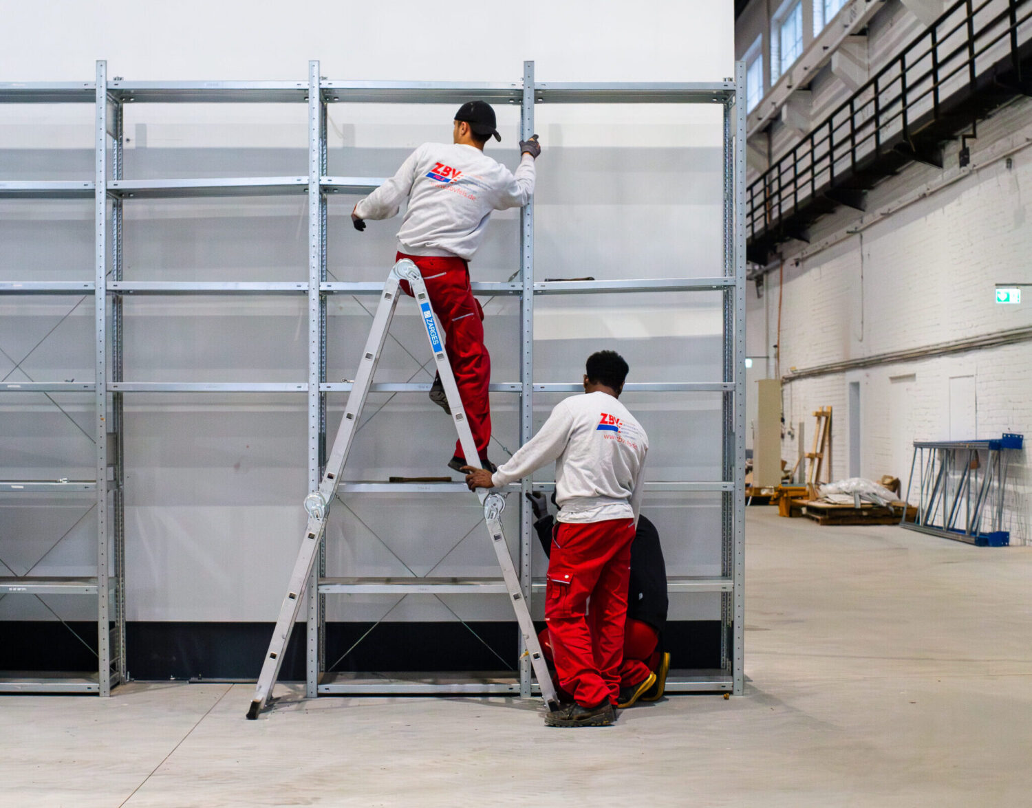 Team baut große Metallregale in einer Lagerhalle auf