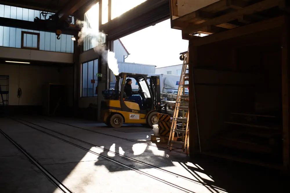 Gabelstapler in einer Lagerhalle mit Sonnenlicht und Schatten.